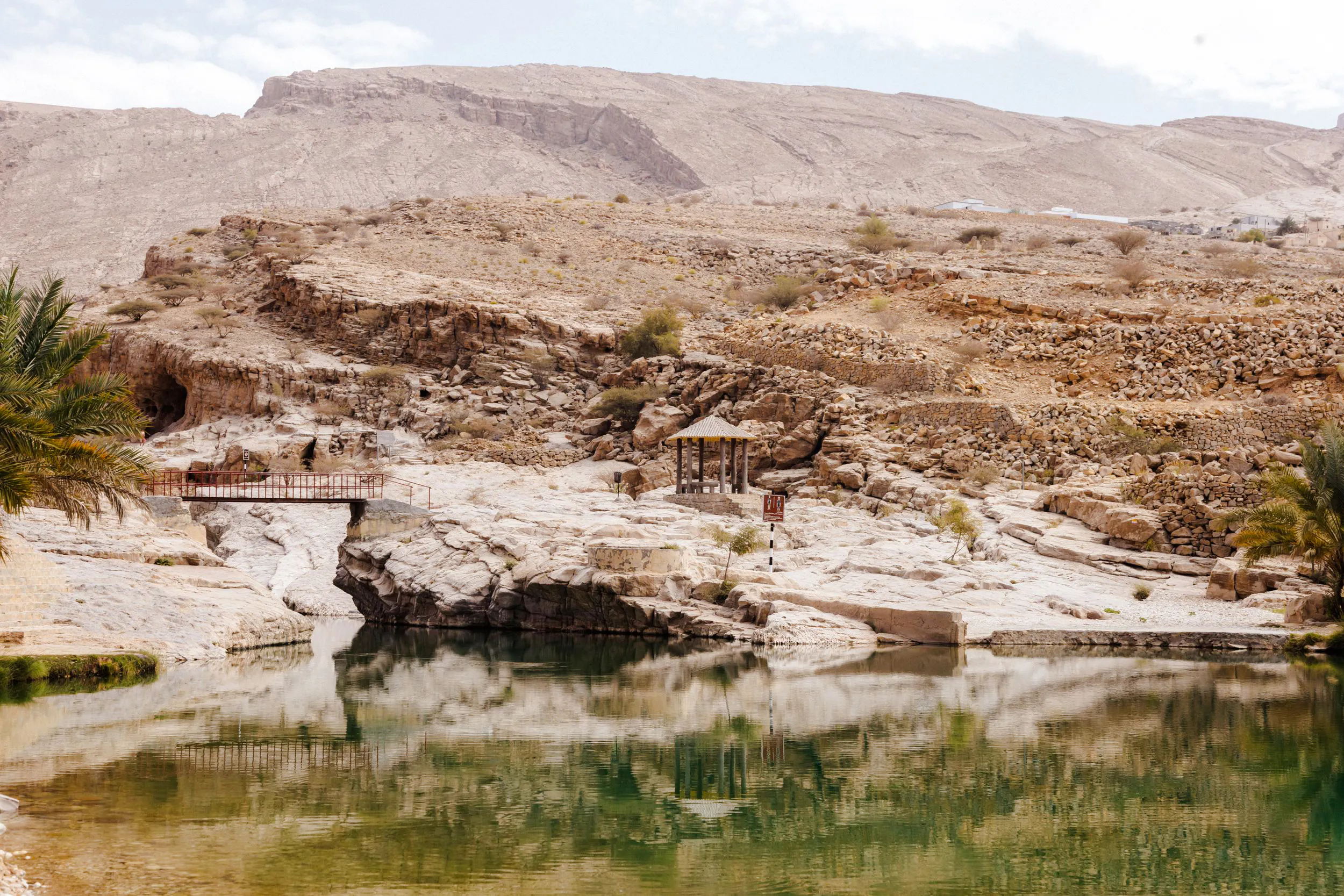 Wadi Bani Khalid oasis with rocky landscape and small pavilion, Muscat tour.