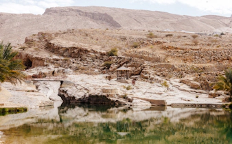 Wadi Bani Khalid oasis with rocky landscape and small pavilion, Muscat tour.