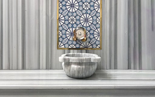Marble basin and ornate tile wall inside Sifa Hamam.