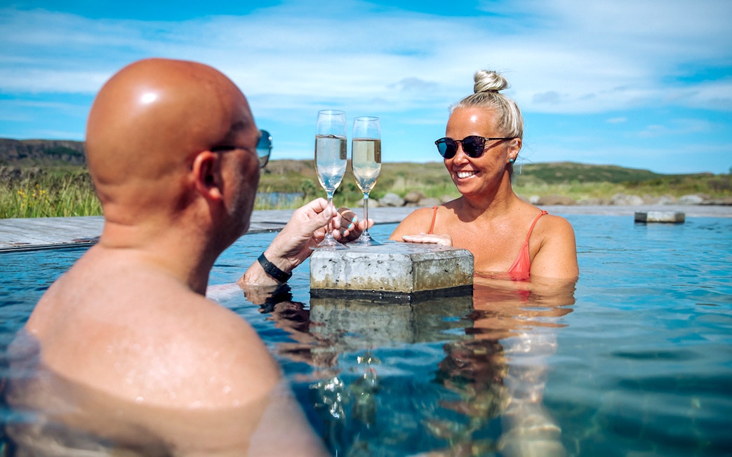 Guests toasting with drinks at Vok Baths in Iceland.