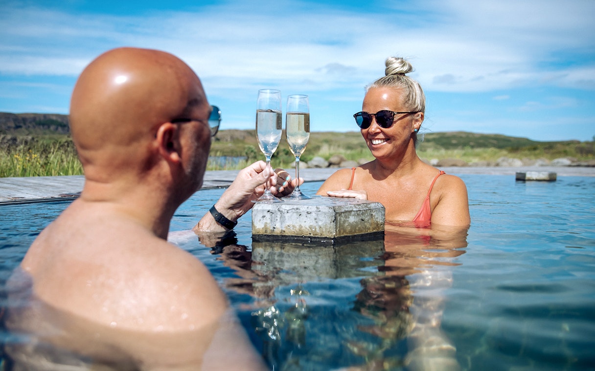 Guests toasting with drinks at Vok Baths in Iceland.