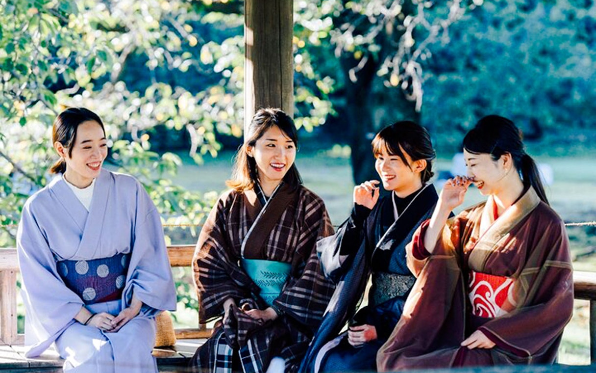 Tourists in kimonos enjoying Tokyo Matcha & Kimono Experience outdoors.