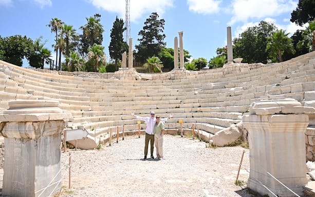 Roman amphitheater in Alexandria, Egypt, with tourists exploring the ancient site.