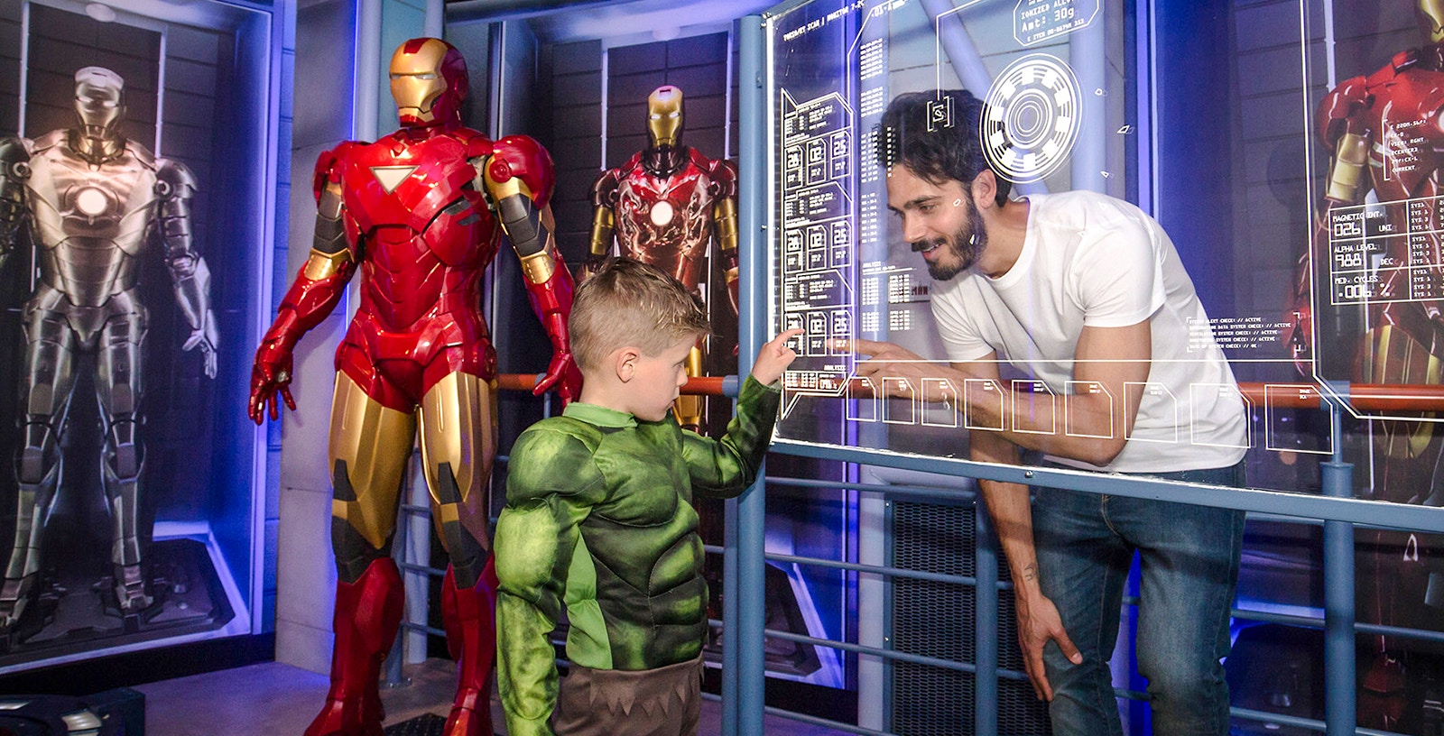 Child in Hulk costume interacting with Iron Man display at Madame Tussauds Amsterdam.