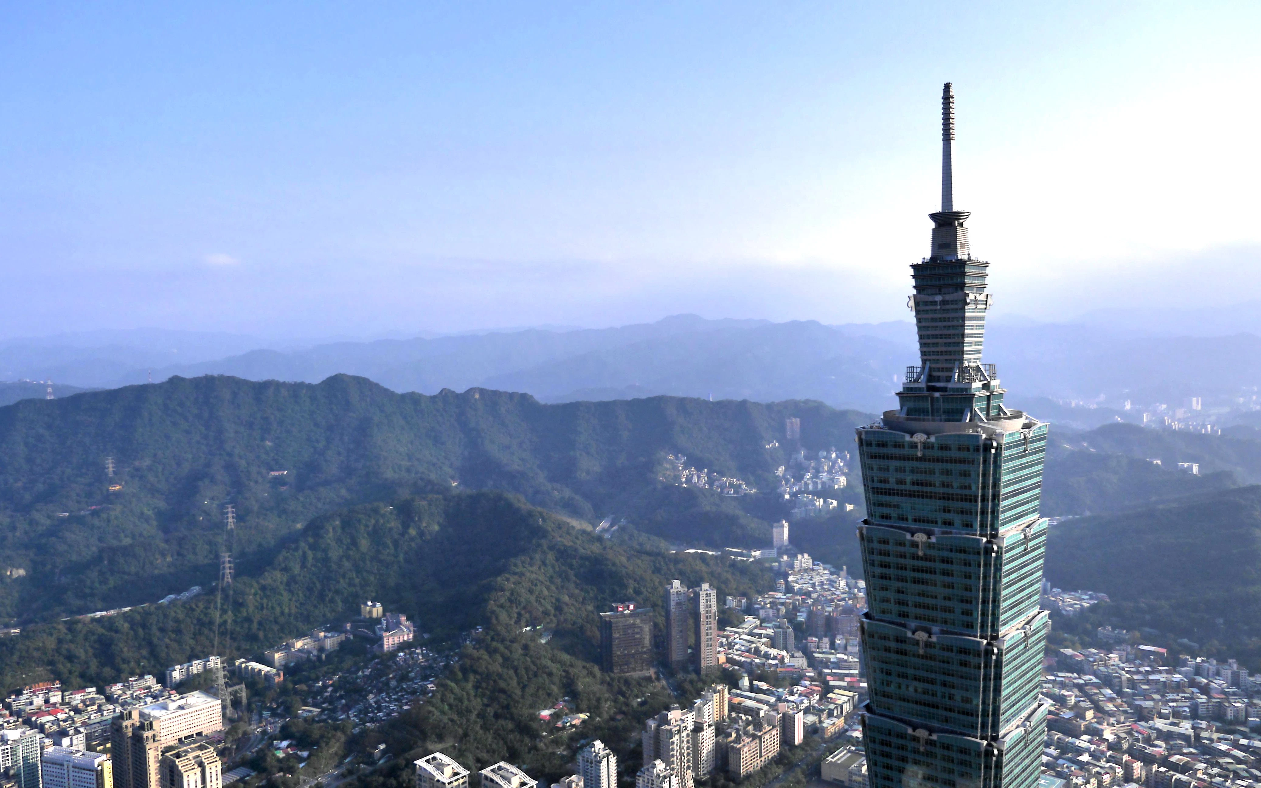 Aerial view of Taipei 101 with surrounding cityscape and mountains in Taipei City, Taiwan.