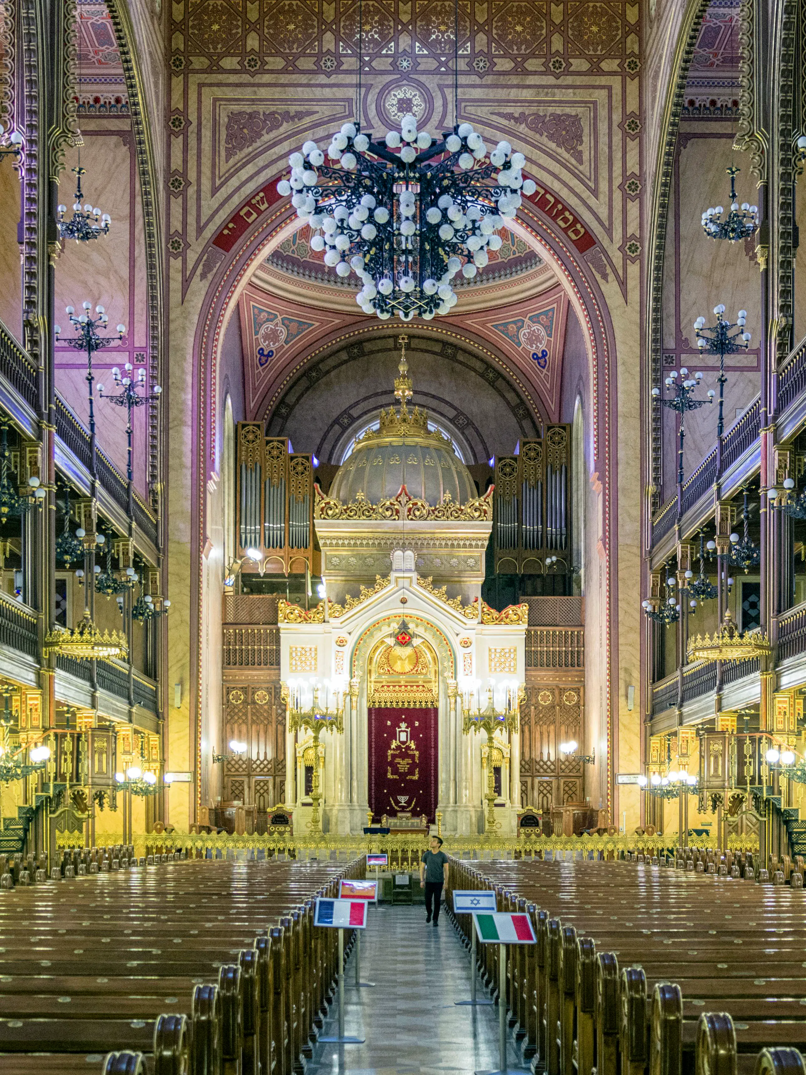 Interior of the Great Synagogue in Budapest with ornate arches and chandeliers.