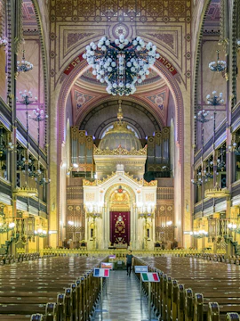 Interior of the Great Synagogue in Budapest with ornate arches and chandeliers.