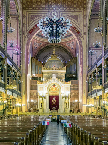 Interior of the Great Synagogue in Budapest with ornate arches and chandeliers.