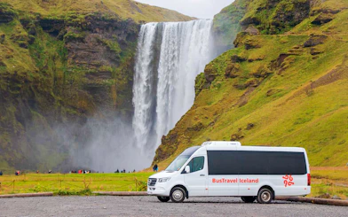 Minivan parked in front of Skogafoss waterfall, South Iceland.