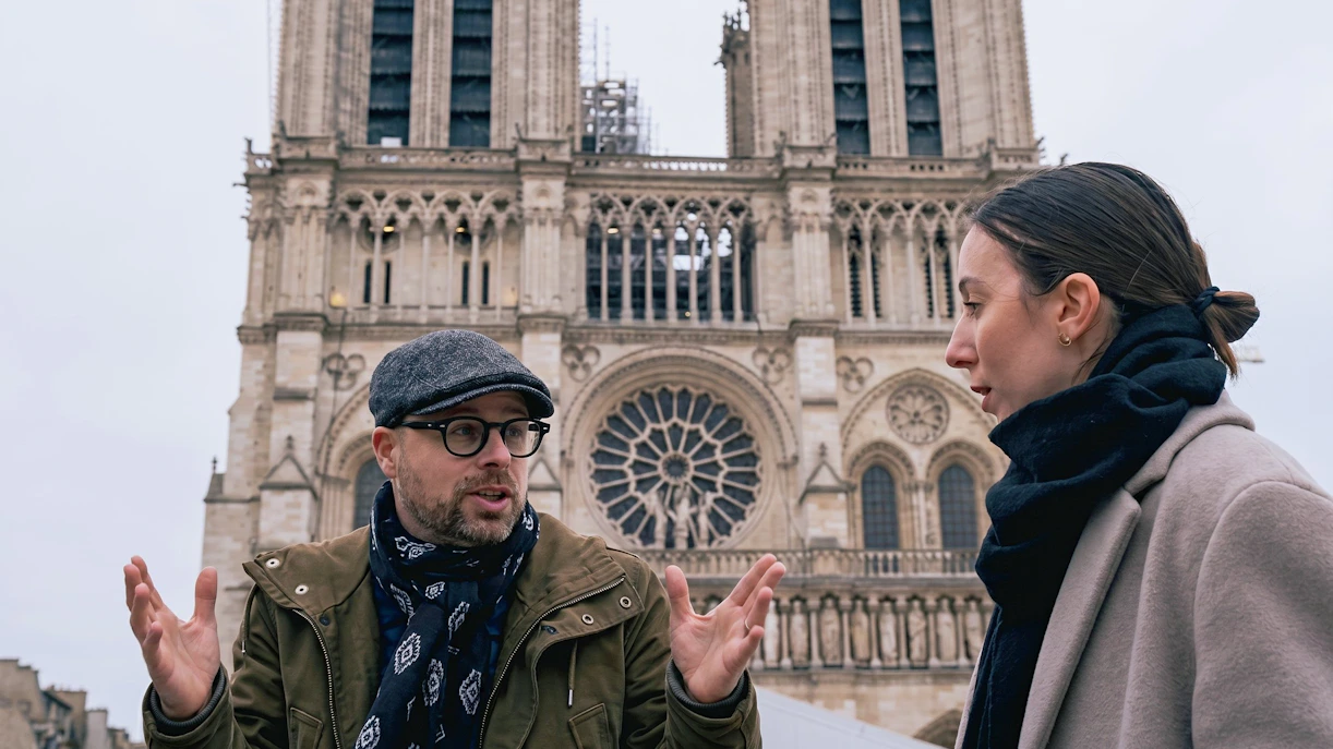 Tour guide explaining Notre Dame's facade to a visitor during a private guided tour in Paris.