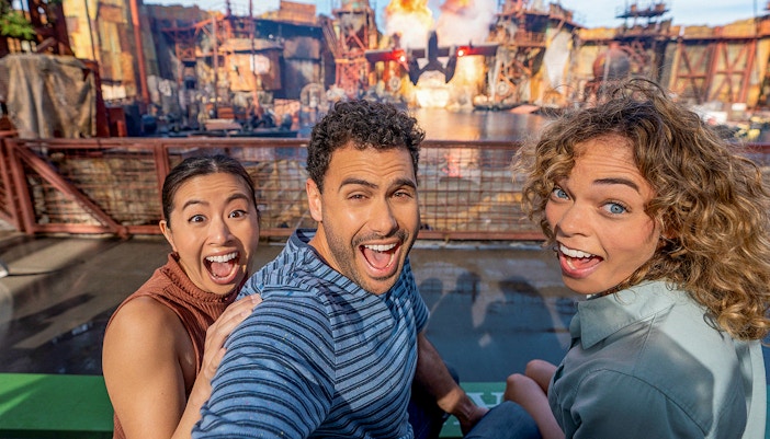 Tourists in a selfie in front of an attraction at Universal Studios Hollywood.
