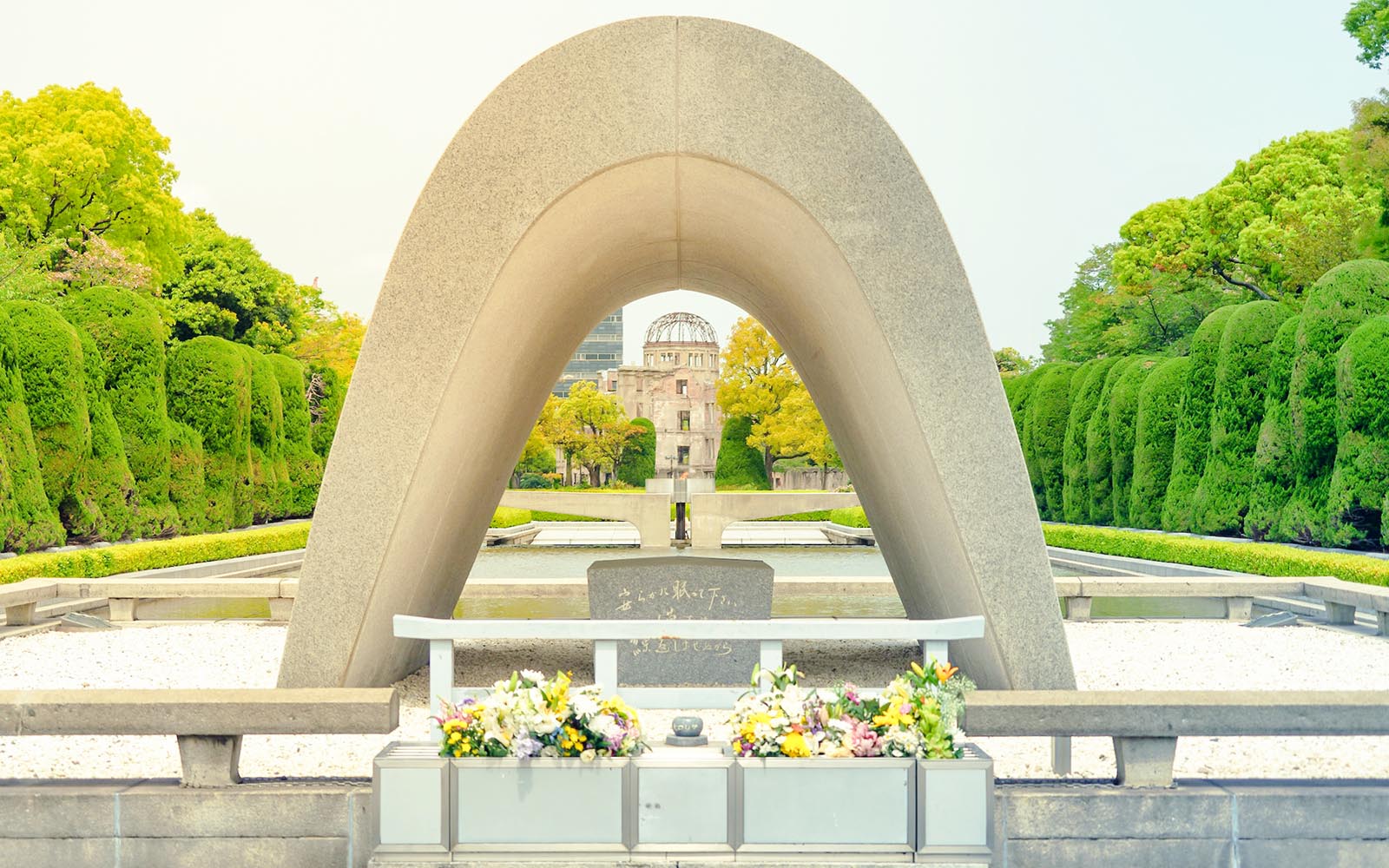 Hiroshima Peace Memorial Park cenotaph with Atomic Bomb Dome in background, Japan.