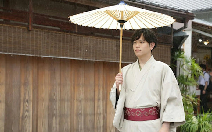 Man in traditional kimono holding a parasol in Kyoto, Japan.