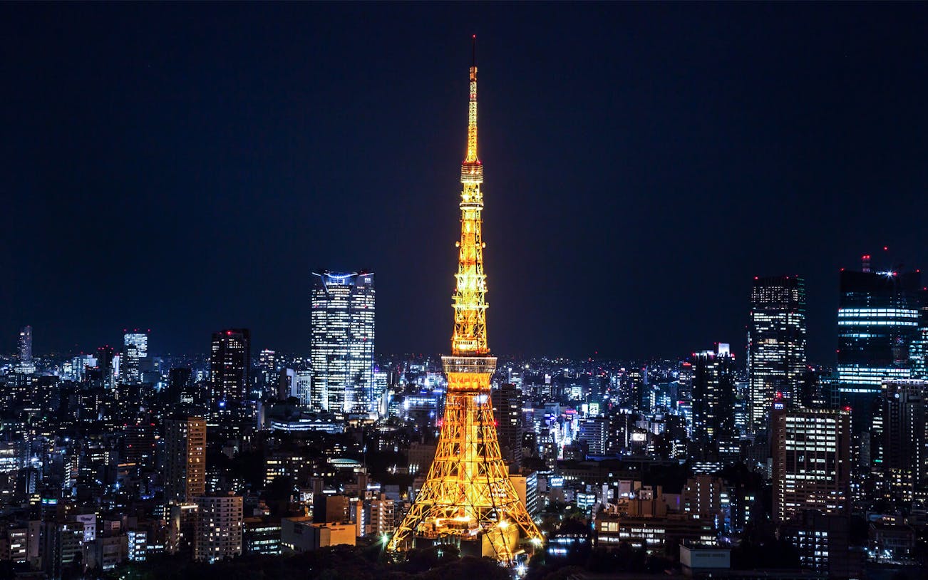 Tokyo Tower illuminated at night with city skyline.
