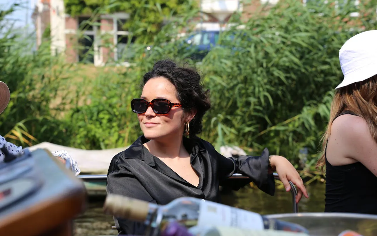 Person enjoying Haarlem canal cruise with greenery in the background.