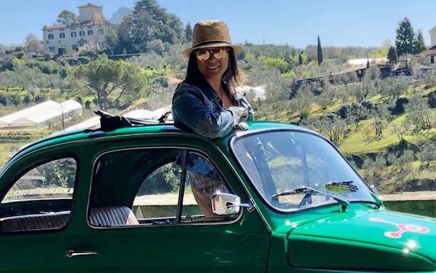 Vintage Fiat 500 with driver on a scenic tour near Florence countryside.