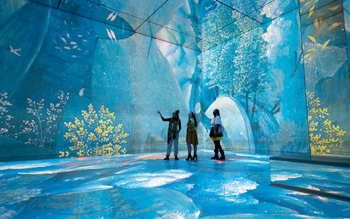 Visitors exploring immersive digital art at Frameless London exhibit.