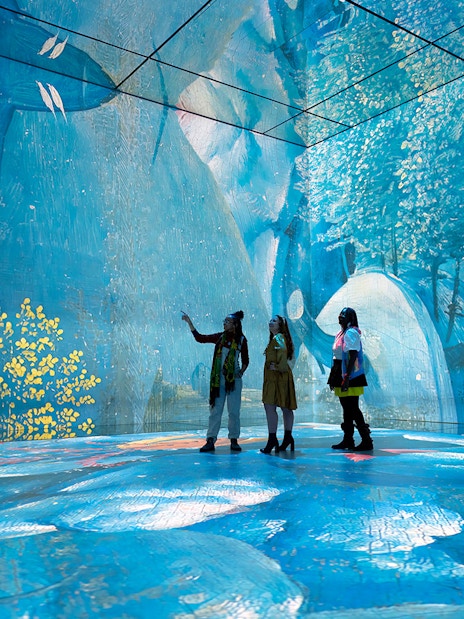 Visitors exploring immersive digital art at Frameless London exhibit.