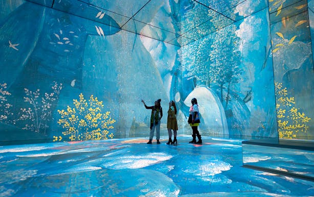 Visitors exploring immersive digital art at Frameless London exhibit.