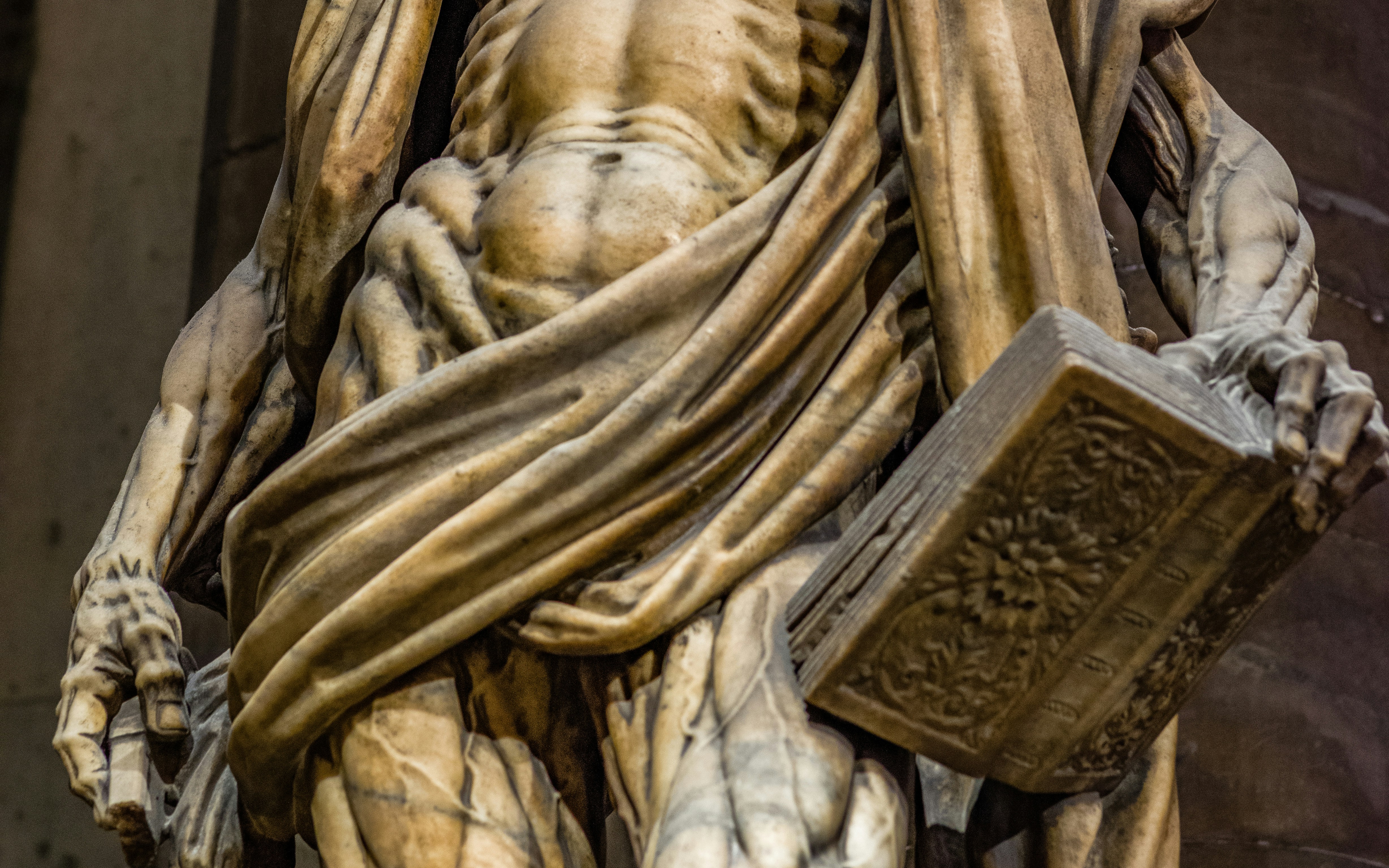 Saint Bartholomew statue closeup holding a book in Duomo Milan.