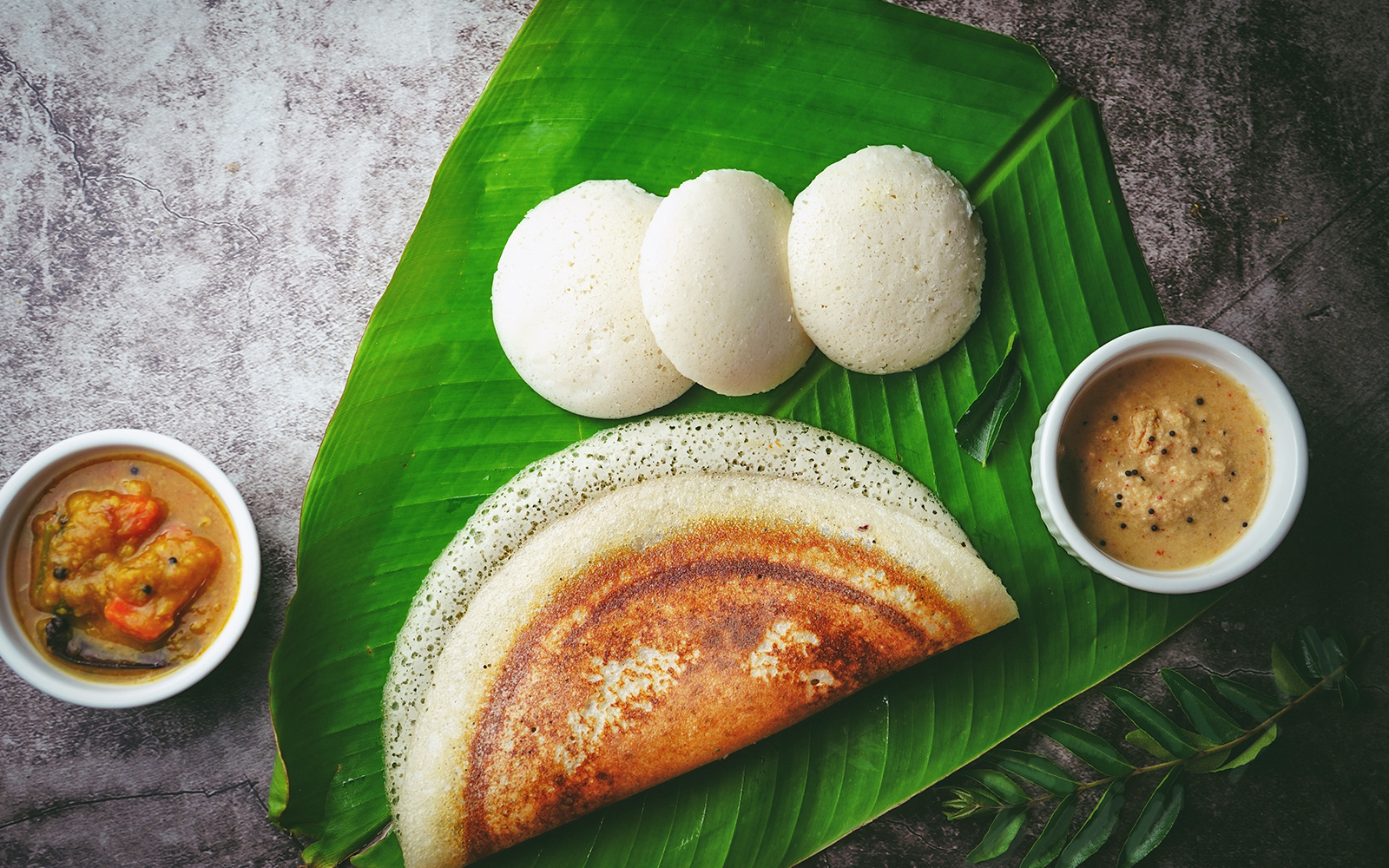 South Indian breakfast Idli Dosa sambar and chutney served in banana leaf