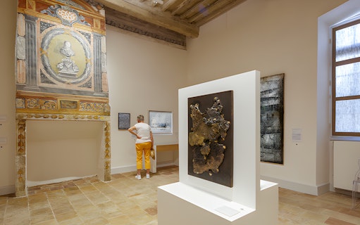 Visitor viewing art inside Beaulieu-en-Rouergue Abbey, France.