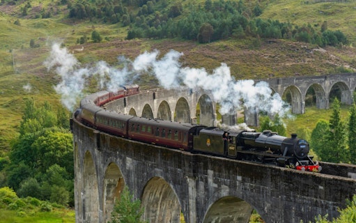 Steam train crossing the Glenfinnan Viaduct in Scotland.