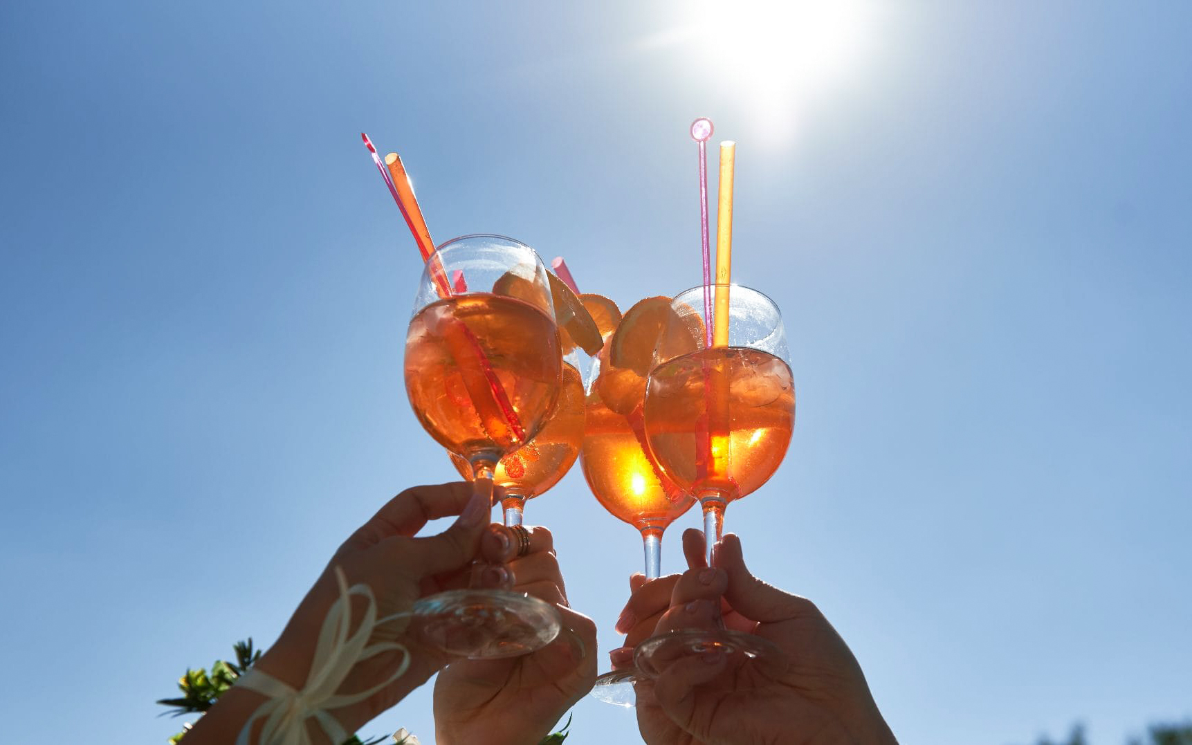 Aperitif drinks raised in a toast on Navigli canal cruise in Milan.