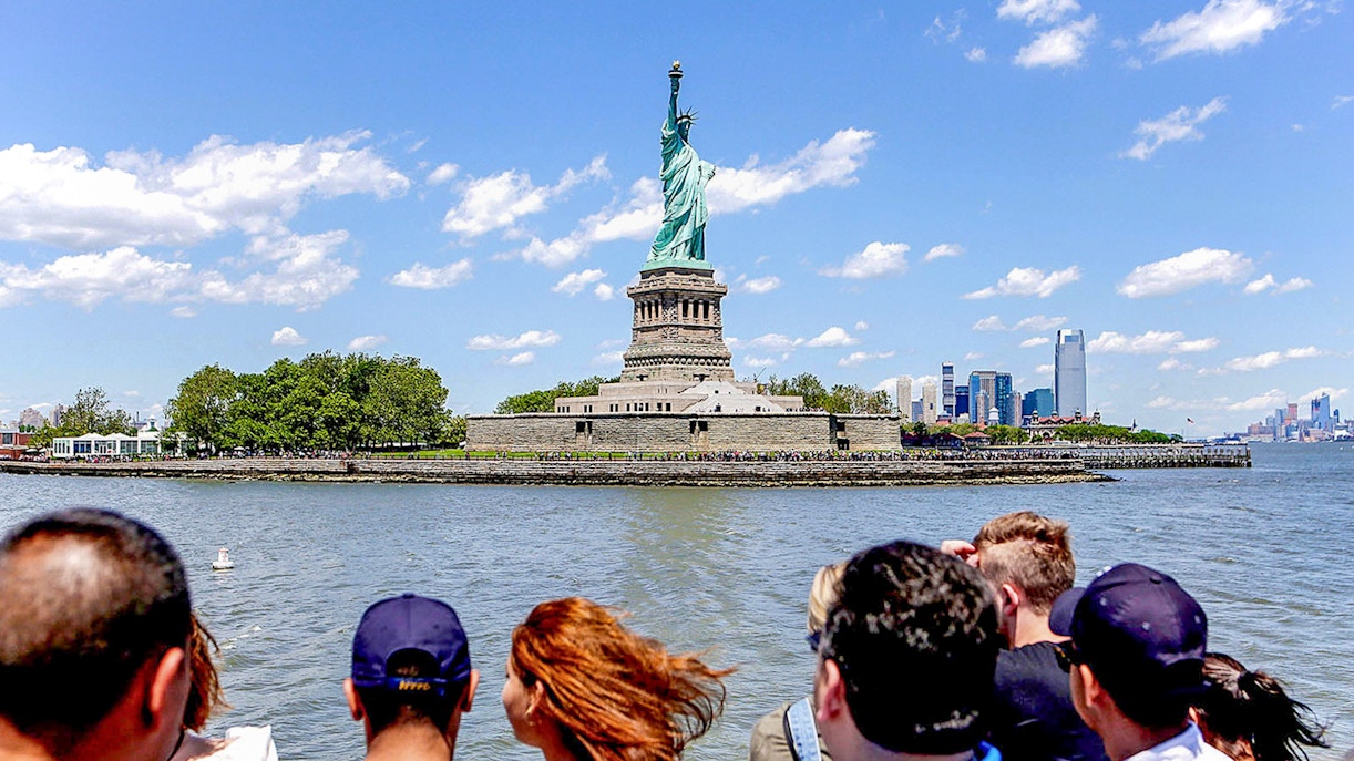 Tourist viewing Statue of Liberty from New York City sightseeing cruise