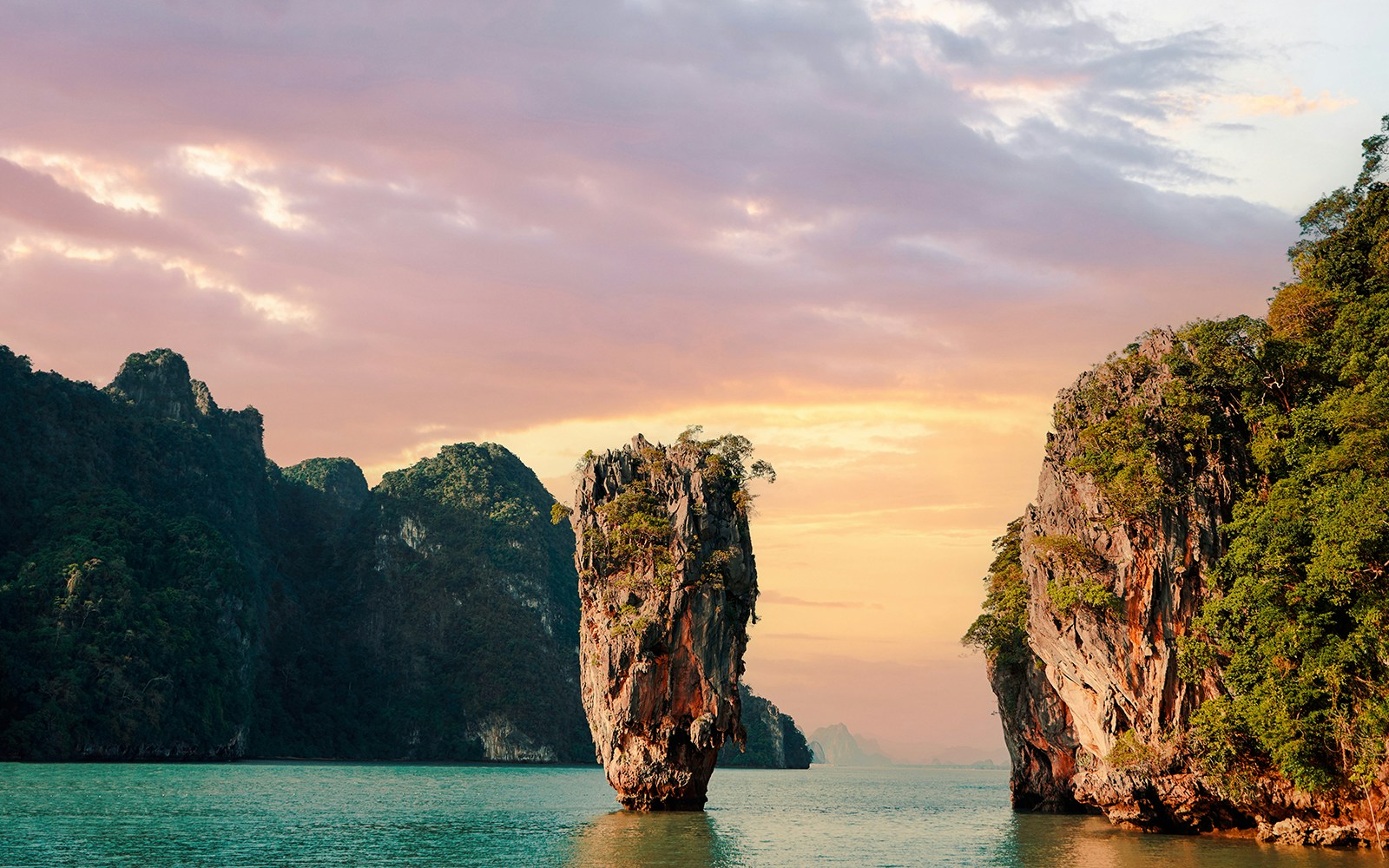 James Bond Island at sunset with limestone cliffs in Phang Nga Bay, Thailand.