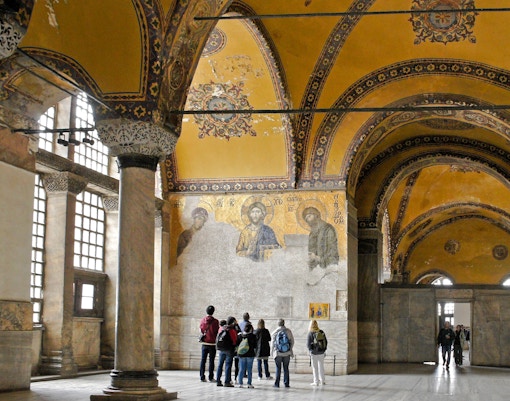 Visitors observing the Deesis mosaic in Hagia Sophia, Istanbul, Turkey.