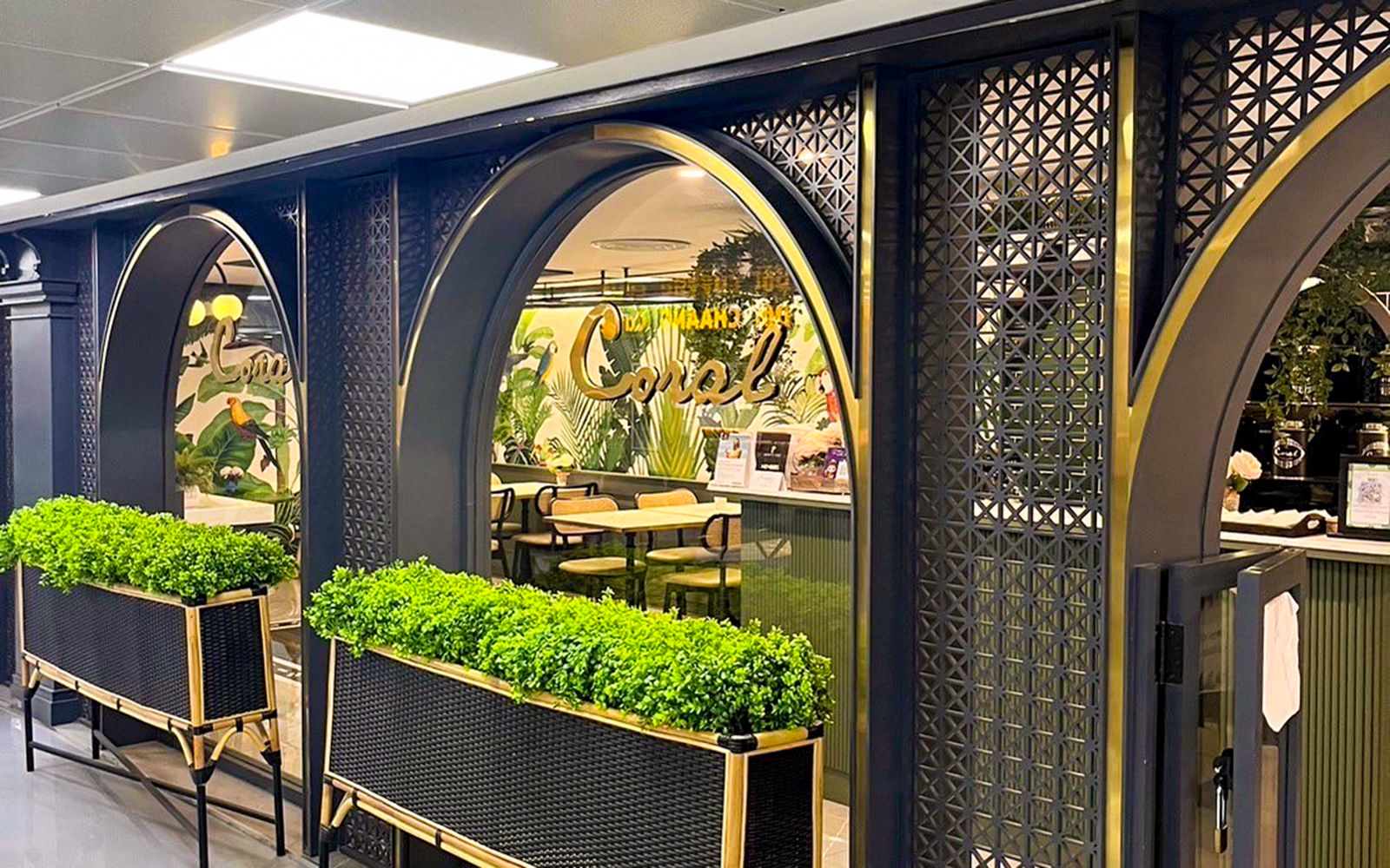 Forest Lounge entrance at The Coral Executive Lounge, Bangkok Airport, featuring lush greenery.