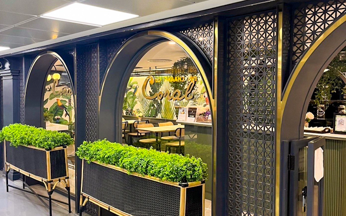 Forest Lounge entrance at The Coral Executive Lounge, Bangkok Airport, featuring lush greenery.