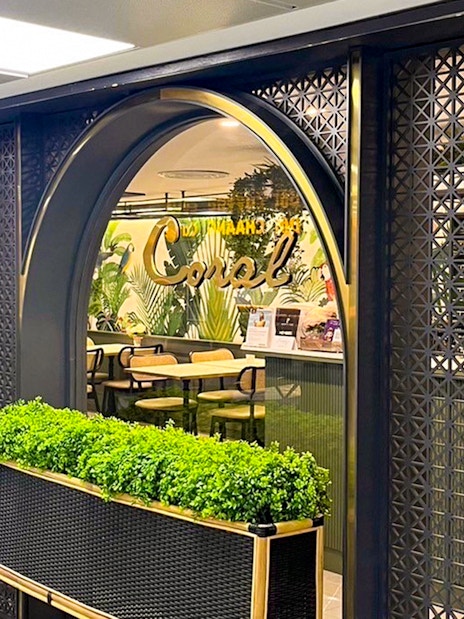 Forest Lounge entrance at The Coral Executive Lounge, Bangkok Airport, featuring lush greenery.