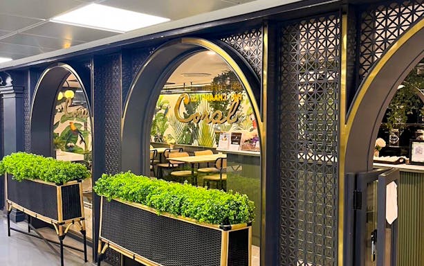 Forest Lounge entrance at The Coral Executive Lounge, Bangkok Airport, featuring lush greenery.