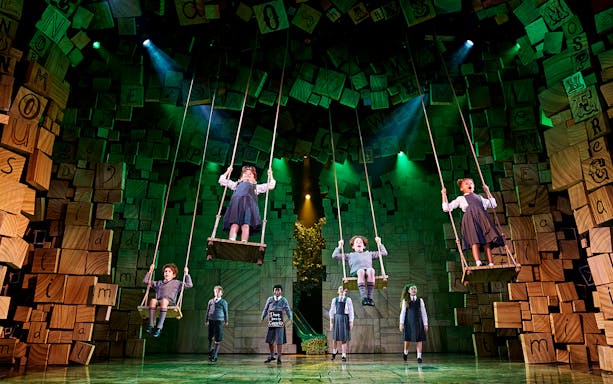 Children on swings during a performance of Matilda The Musical.
