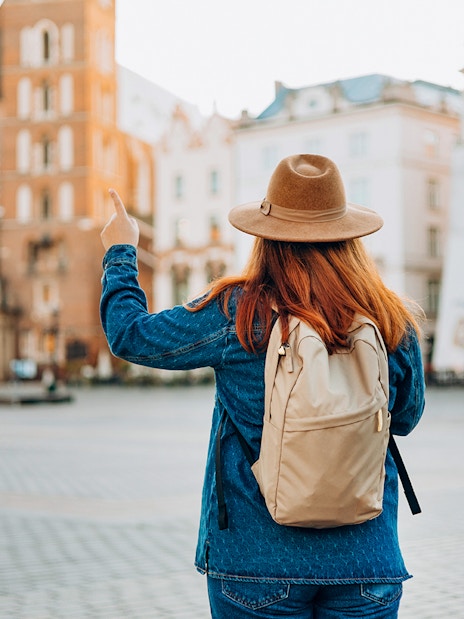 Traveler in Krakow's Old Town pointing at Saint Mary's Basilica.