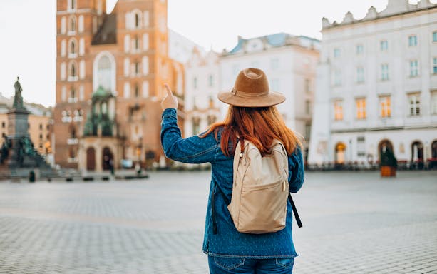 Traveler in Krakow's Old Town pointing at Saint Mary's Basilica.