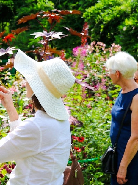 Visitors photographing vibrant flowers at Claude Monet’s gardens in Giverny.