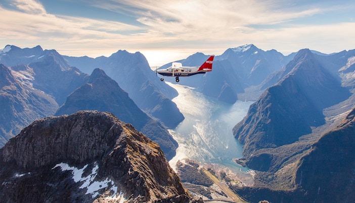Milford Sound aerial view with cruise ship, Queenstown scenic flyover experience.