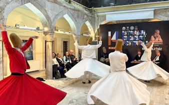 Whirling dervishes performing at Istanbul Sufi ceremony with musicians in the background.