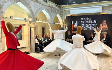Whirling dervishes performing at Istanbul Sufi ceremony with musicians in the background.