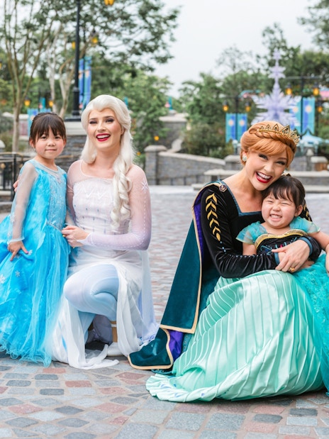 Elsa and Anna with children at Disneyland Hong Kong's Frozen Ever After attraction.
