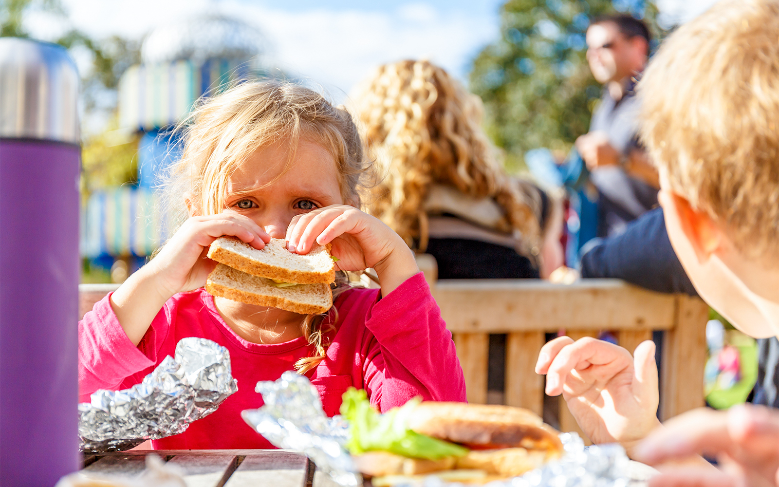 Child enjoying a sandwich during a picnic at Hampton Court.