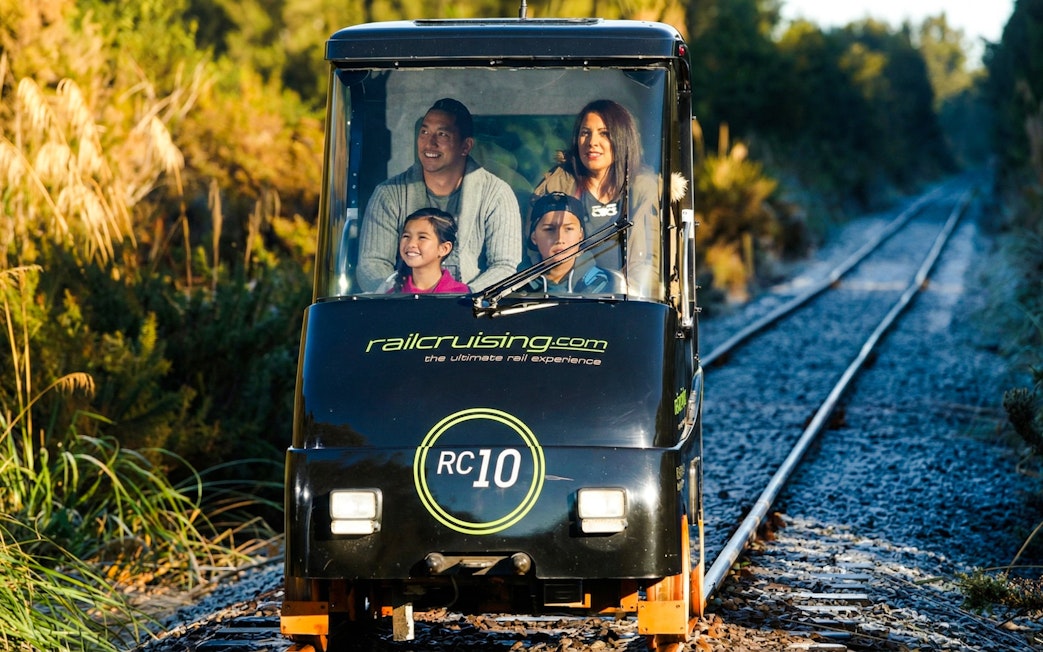 Family enjoying a self-drive rail car on Ngongotaha tracks, New Zealand.