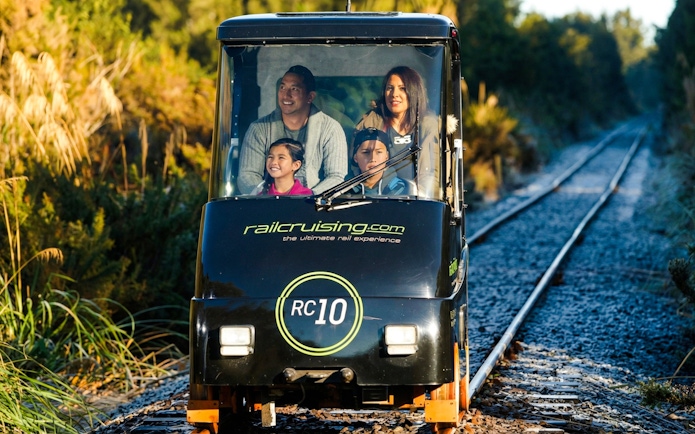 Family enjoying a self-drive rail car on Ngongotaha tracks, New Zealand.