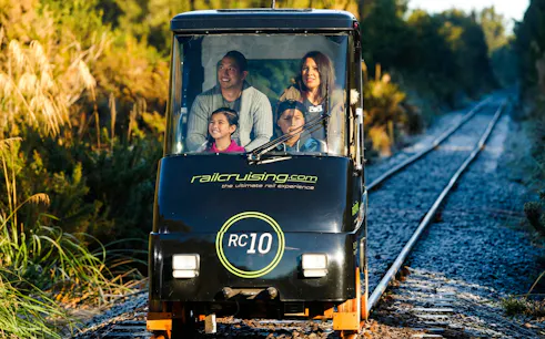 Family enjoying a self-drive rail car on Ngongotaha tracks, New Zealand.