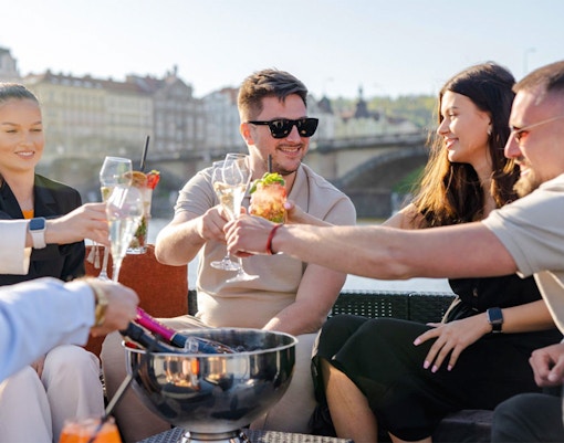 Group of friends enjoying prosecco on a yacht boat in Prague.