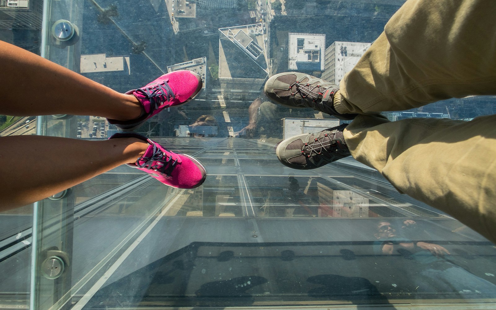 Tourists posing on a glass floor