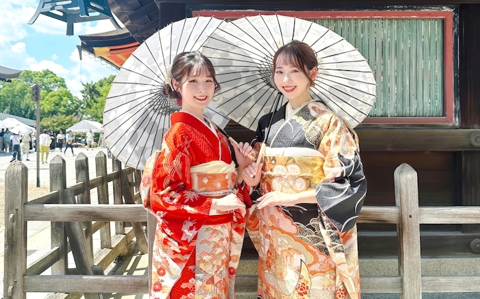 Individuals in traditional kimonos with parasols in Kyoto.